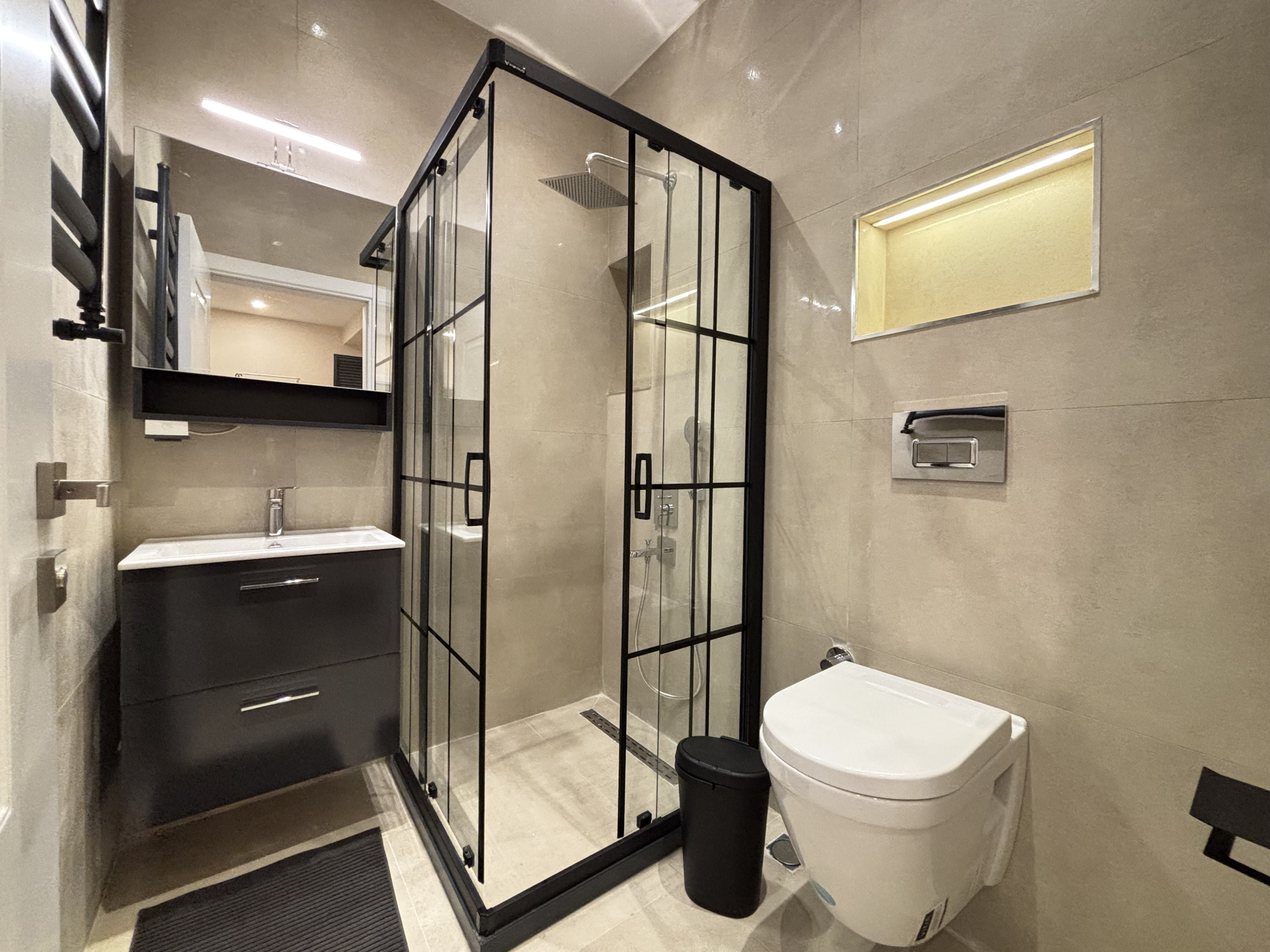 Bathroom with a vanity, toilet and glass-enclosed shower.