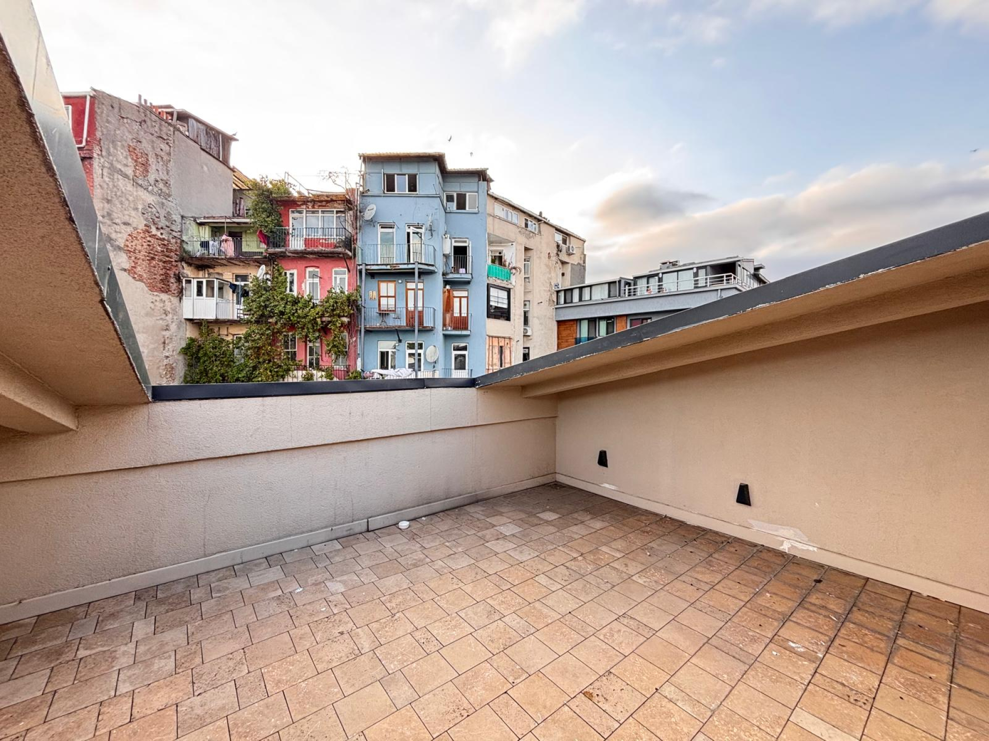 Paved terrace with neighboring buildings in the outlook.