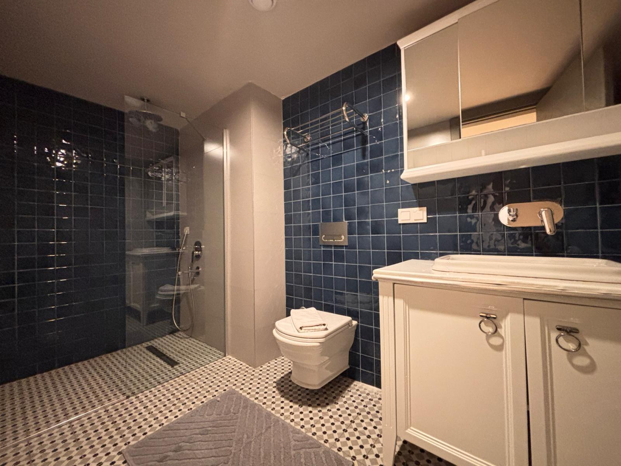 Bathroom with vanity, toilet and glass shower enclosure.