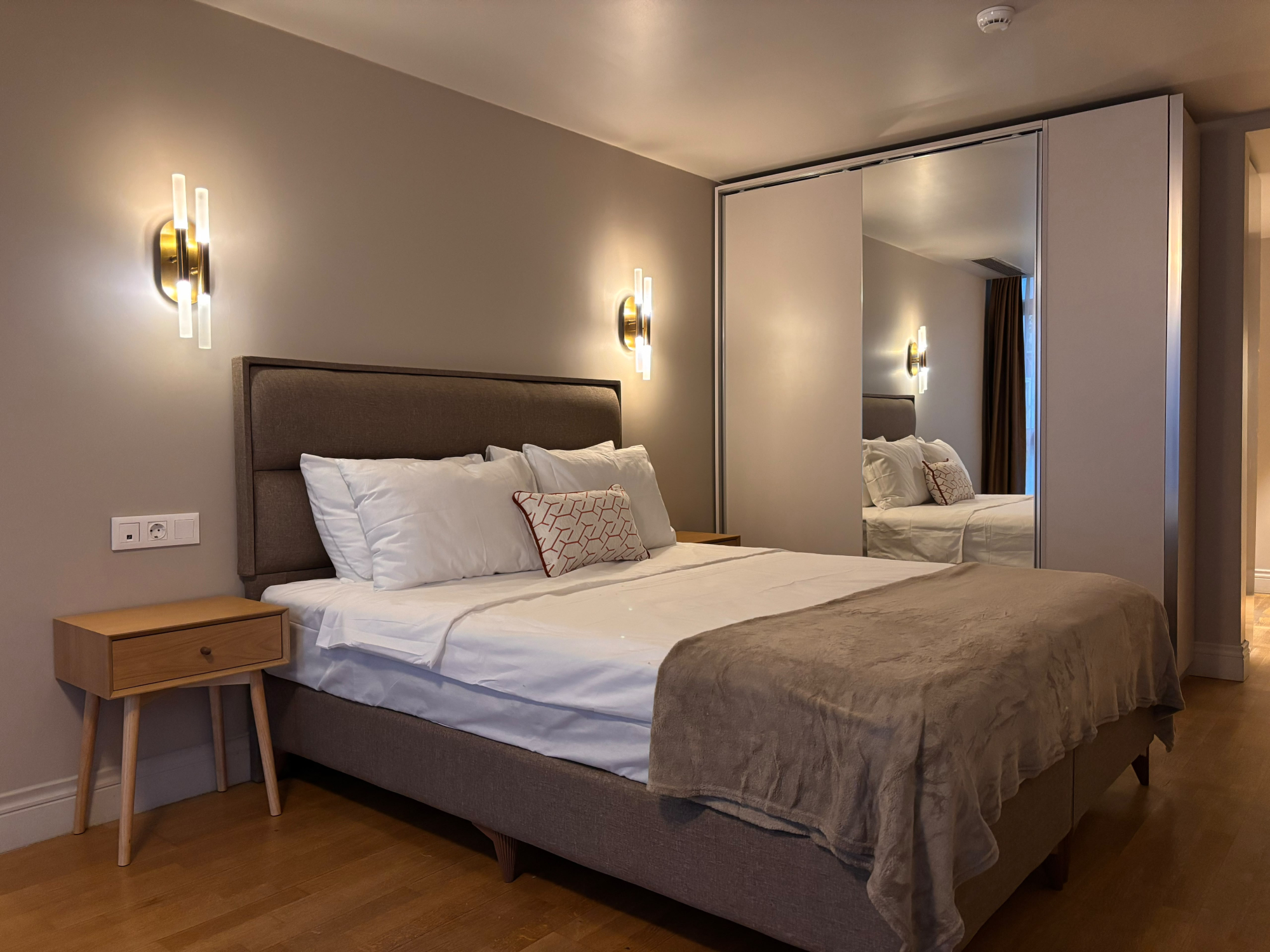 Sleeping area with double bed, bedside table and mirrored wardrobe.